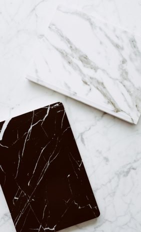 High-quality close-up of contrasting white and black marble tiles on a smooth surface.